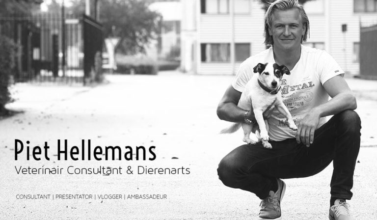 Een man gehurkt op straat houdt een kleine hond in zijn armen. De zwart-witfoto straalt een rustige en vriendelijke sfeer uit.